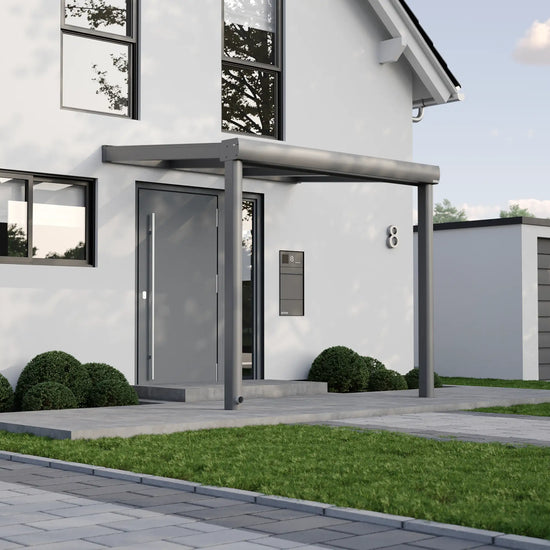 Alufuchs Curved Eingangsüberdachung Wandgebunden aus Aluminium in Anthrazit an modernem Einfamilienhaus – stilvoller Schutz für den Eingangsbereich