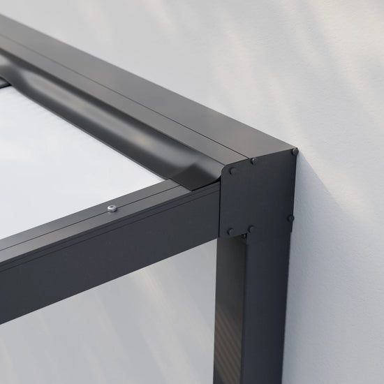 Freistehende Alufuchs Überdachung mit VSG Glas Opal – Detailansicht der Dachanbindung an die Hauswand